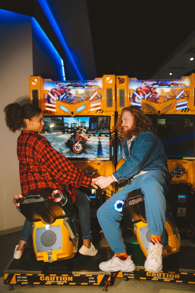Couple competing on arcade bike machines