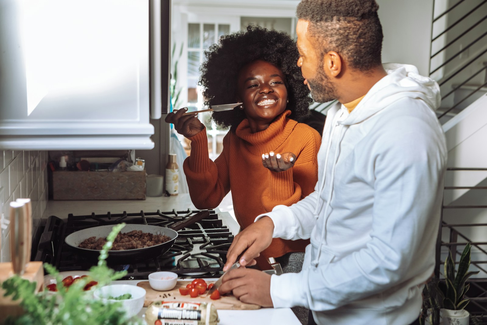 Couple laughing while cooking together at home