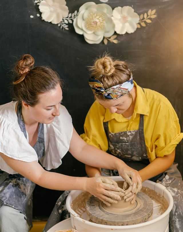 Couple shaping clay together during a pottery workshop date