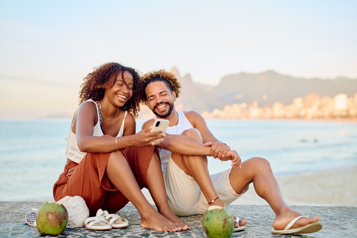 Couple relaxing on the beach with coconut drinks