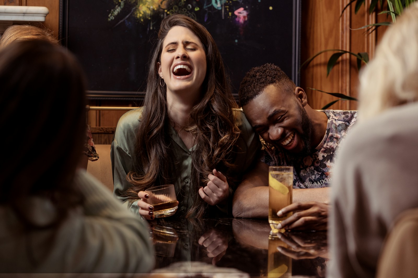 Group of friends laughing over dinner and drinks