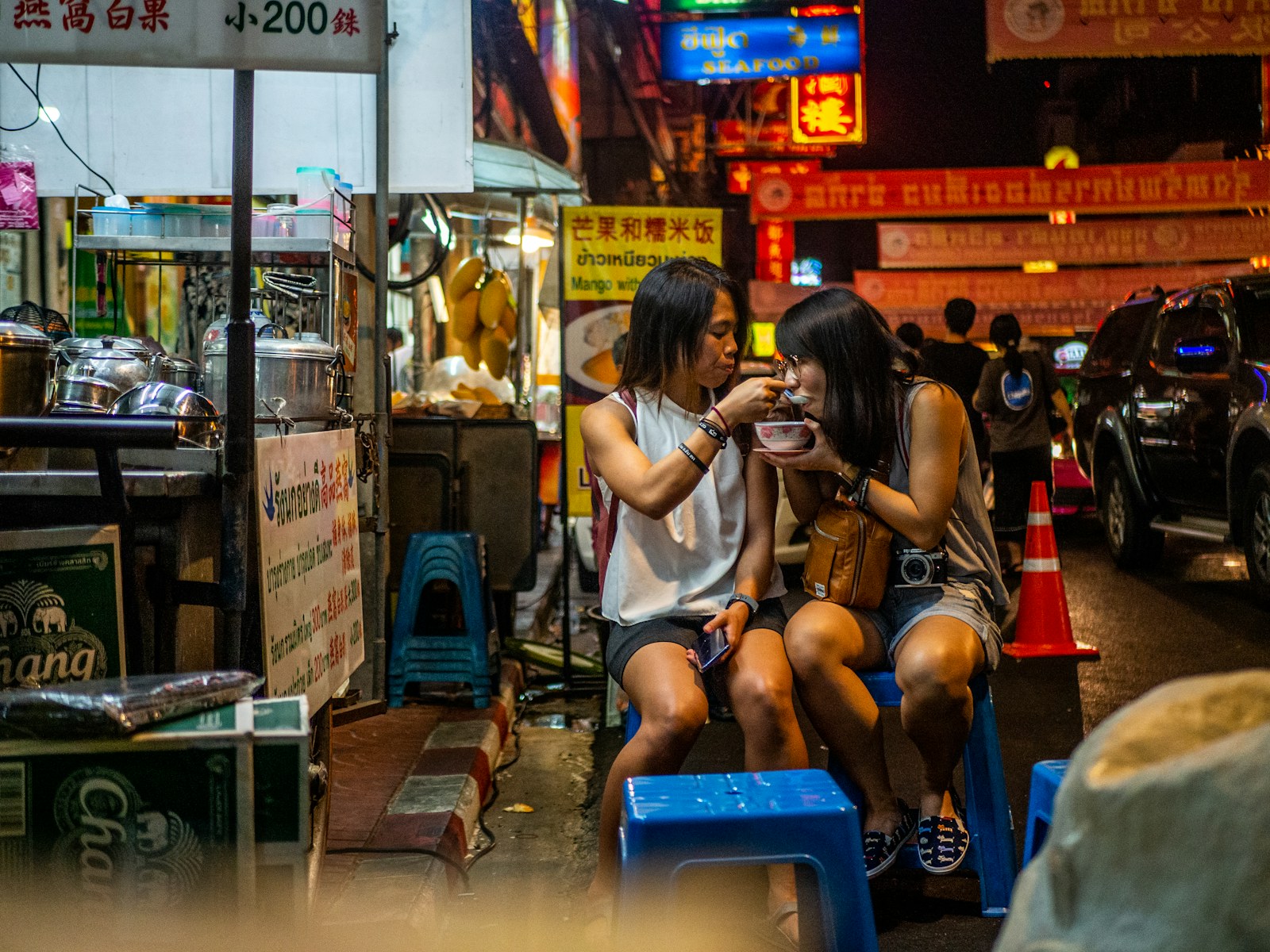 Two people sharing street food at an outdoor night market