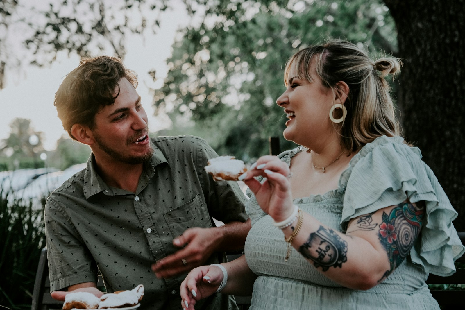 Couple laughing while sharing a dessert outside