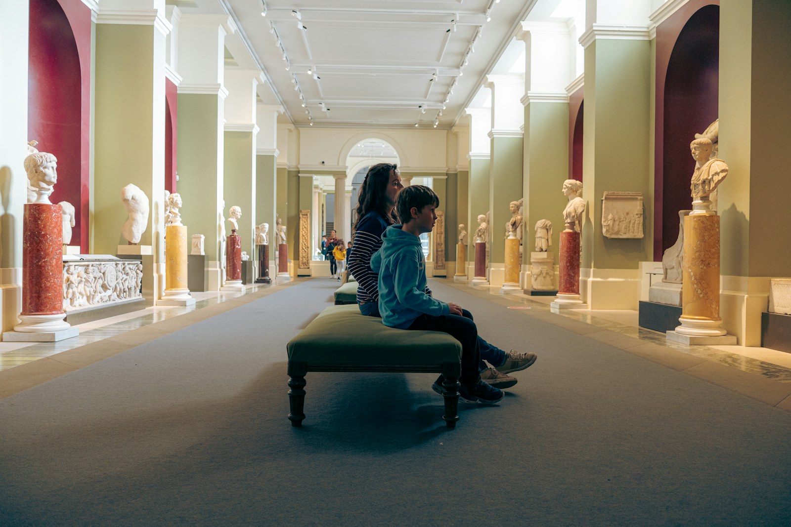 Couple sitting together on a bench in a museum gallery